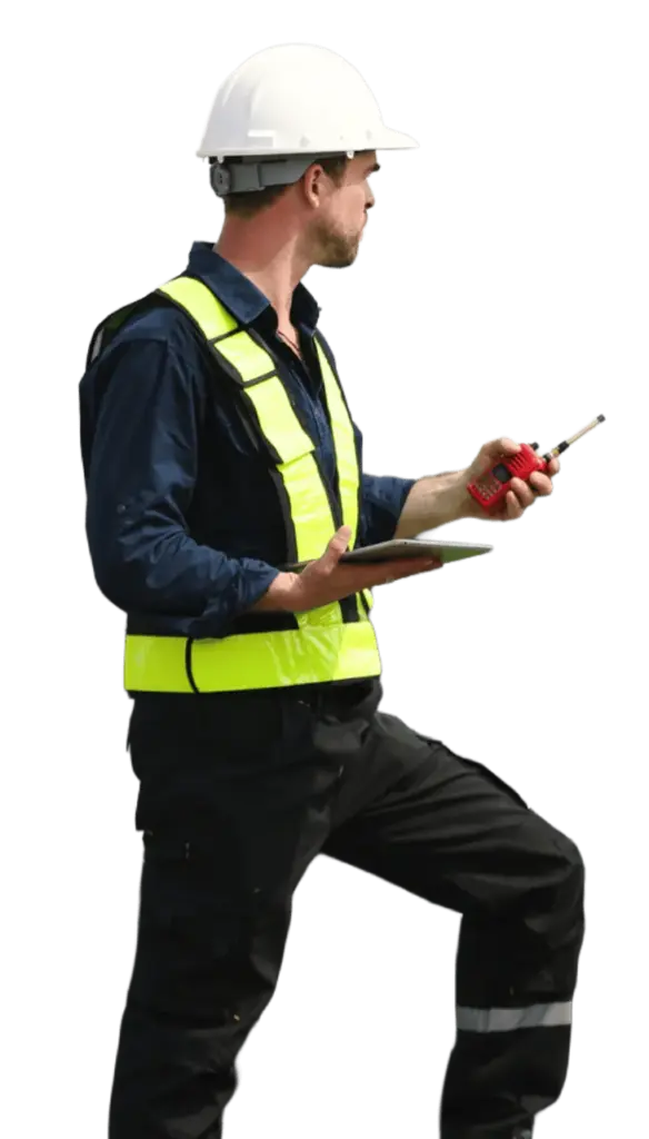Mann mit Warnweste, Arbeitskleidung und weißem Helm hält ein Funkgerät und ein Tablet in den Händen